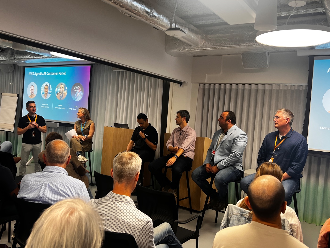 AWS Agentic AI customer panel on stage in front of a full audience, with speakers from Randstad, EPAM and AWS.