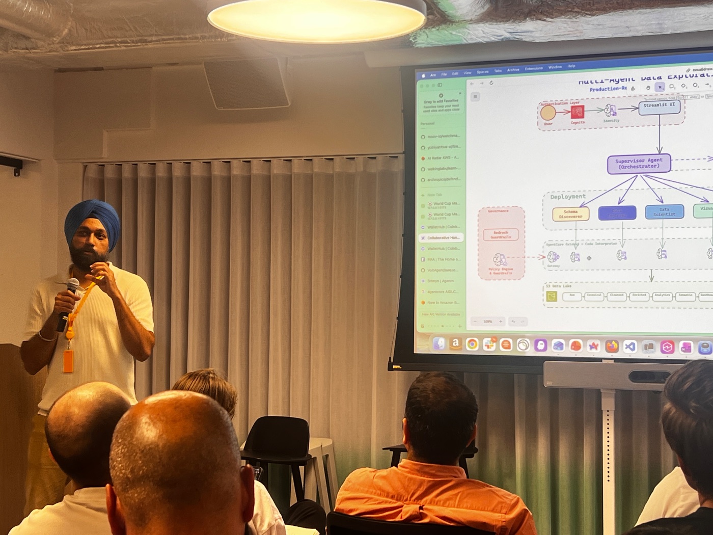 A speaker presenting a multi-agent architecture diagram with a supervisor orchestrator agent fanning out to specialist agents.