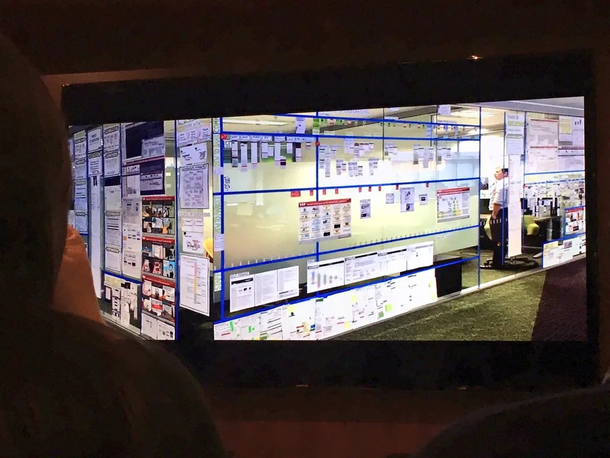 Photo of a large glass-wall visual-management board covered in sprint and kanban artefacts.
